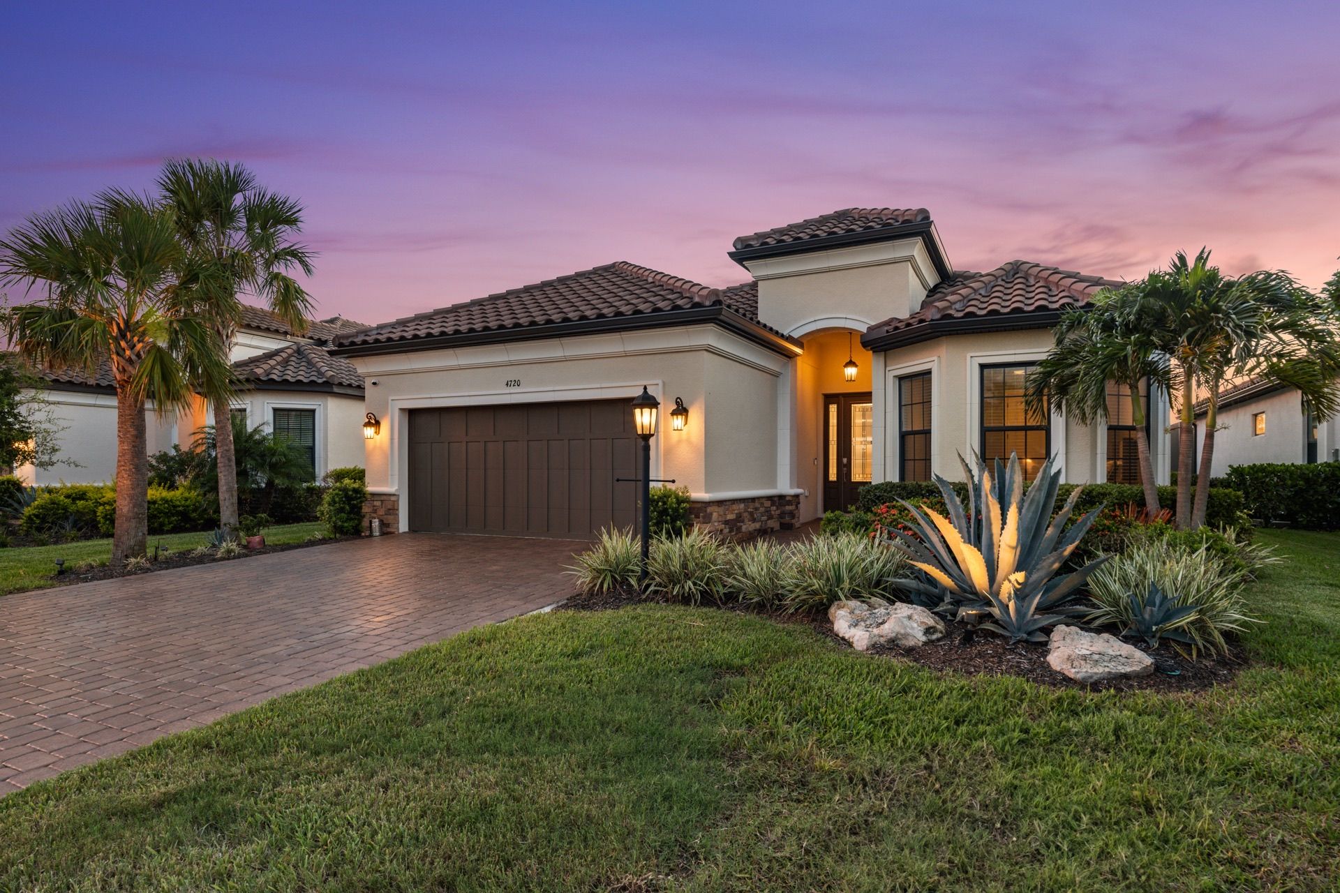 A Lakewood Ranch home at twilight with the entry and garage lanterns lit